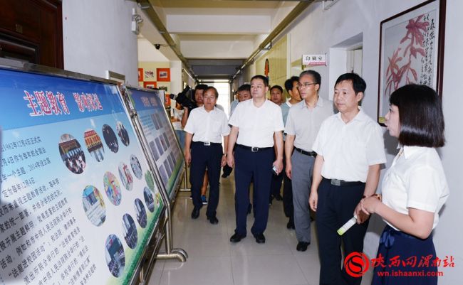 樊存弟一行在渭南实验初级中学观看法治宣传展板。记者 许艾学 摄