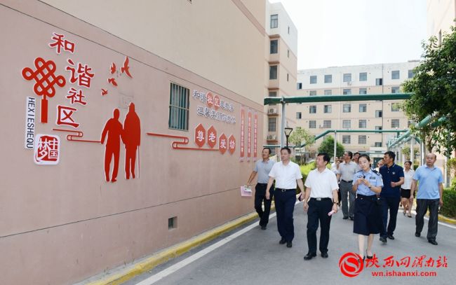 樊存弟一行在站南街道青青家园观看法治长廊。记者 许艾学 摄