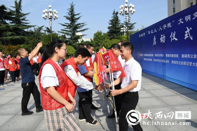 出席启动仪式的领导给16支文明交通志愿服务队代表发放文明交通劝导小红旗、手持点赞牌及口哨。记者 闫少波 摄