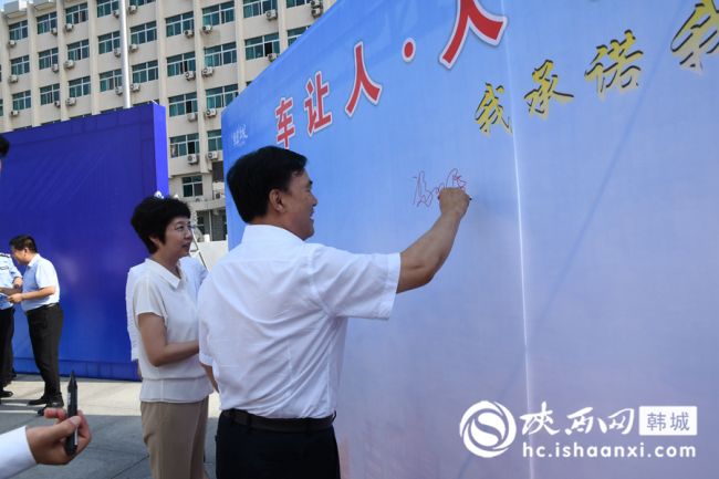 韩城市政协主席冯双民,市委常委、宣传部长沙利娜到承诺墙签名。记者 闫少波 摄