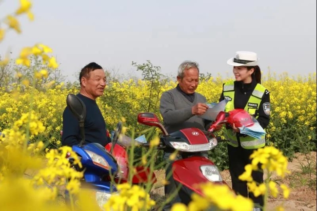 澄城交警在田间里向村民宣传交通安全。