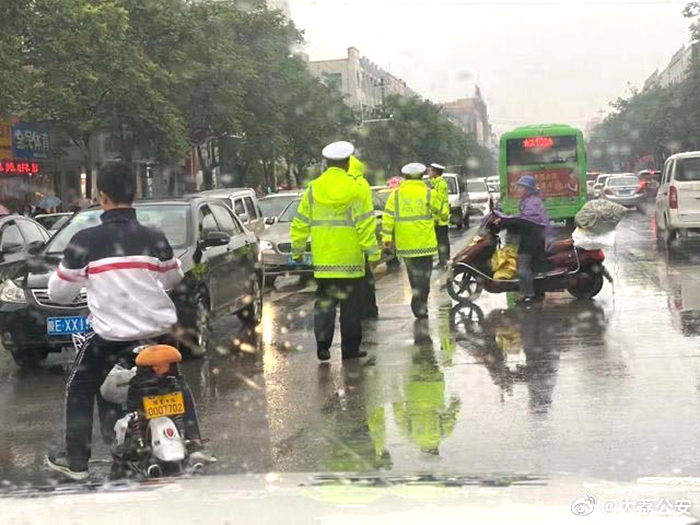 大荔公安交警冒雨坚守岗位，对接送学生家长、社会车辆进行有序疏导。