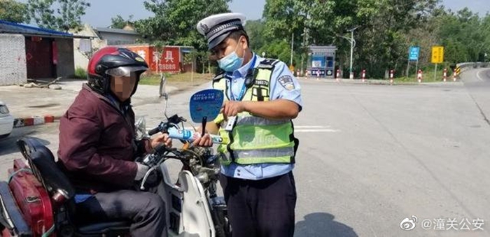 6月18日，潼关公安交警大队民警为农村驾驶员送上一把把制作精美的清凉扇。