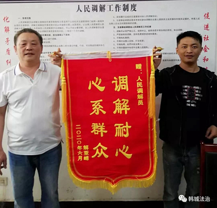 纠纷案的当事人李某之子将一面写着"调解耐心 心系群众"字样的锦旗,送
