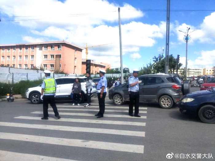 图为白水公安交警保畅小分队在白水一中门口进行交通疏导。