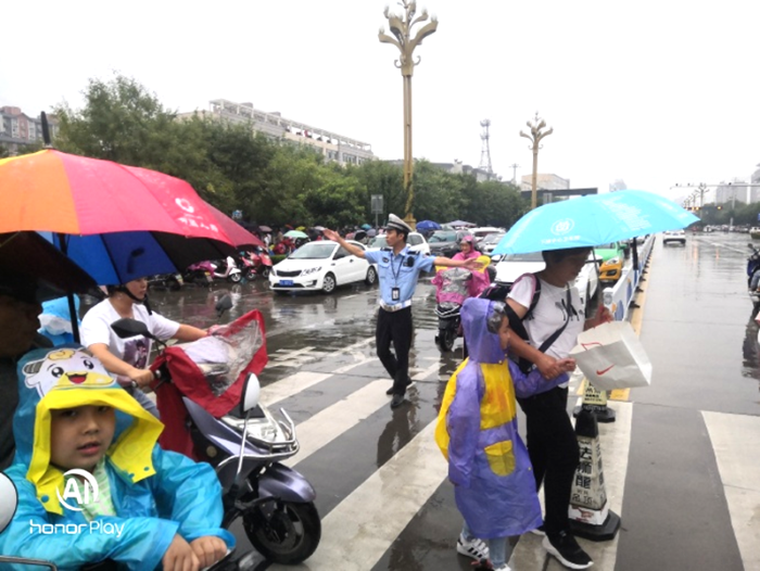 9月9日，华州交警冒雨护送学生安全通过马路。