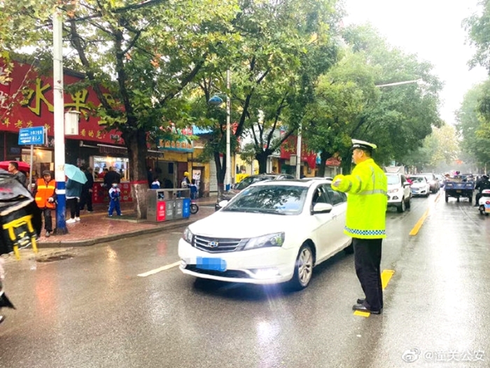 10月13日，潼关公安交警大队“护学岗”民警冒雨坚守岗位，确保雨天校园周边道路交通安全。 