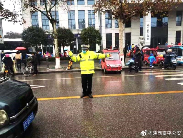 12月1日，富平公安交警坚守“护学岗”，冒雨提前到达各执勤点，对过往车辆进行分流引导、疏导交通、护送学生过马路。