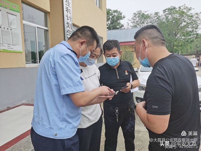 大荔公安双泉派出所民警向群众推广“国家反诈中心App”。