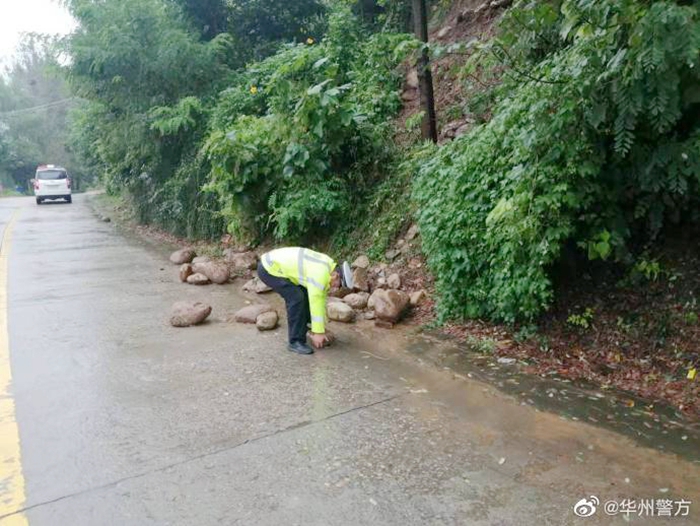 华州民警将路面落石清理干净，及时消除安全隐患。