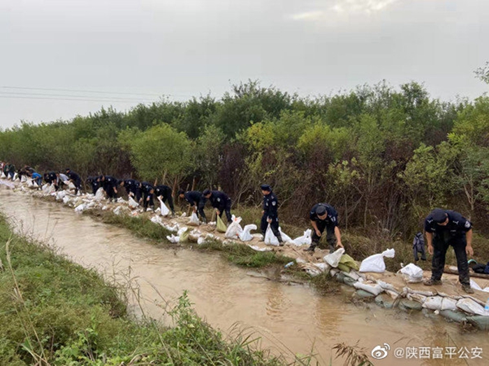 10月7日，富平公安民警全力配合党委镇政府担起抗洪抢险任务，对河道漏洞进行加固。