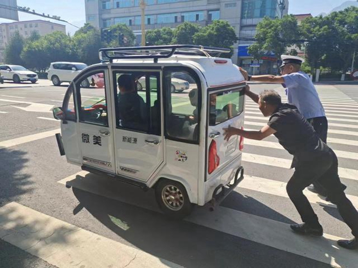车辆故障停路中，交警推车保畅通。