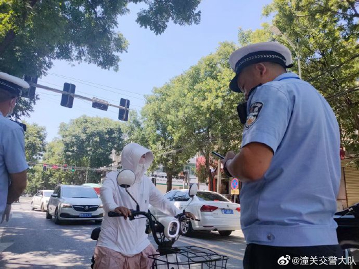 潼关县公安局交警大队潼洛中队执勤民警持续开展电动自行车不佩戴安全头盔整治行动。