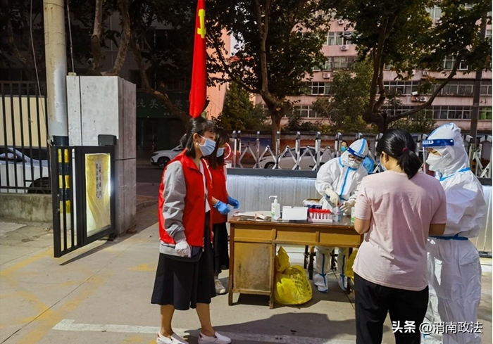 临渭区司法局党员干部在新世纪社区参与核酸检测工作。