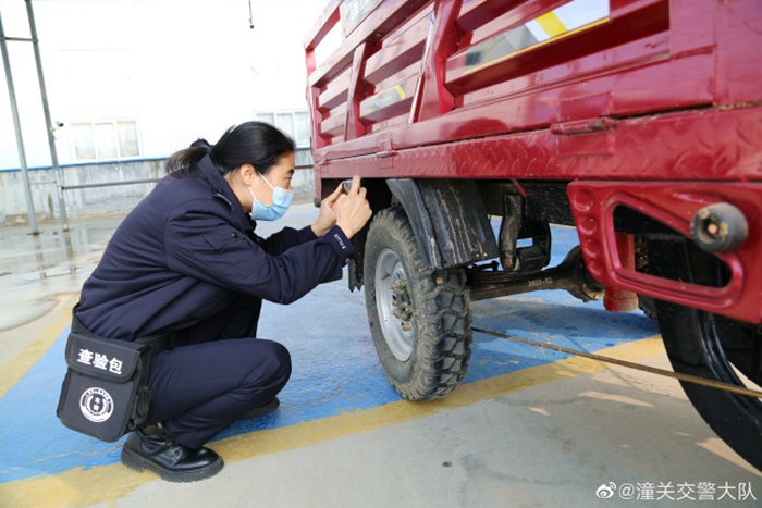 潼关交警对农用三轮车底盘间隙和出厂编号进行查验拍照登记。