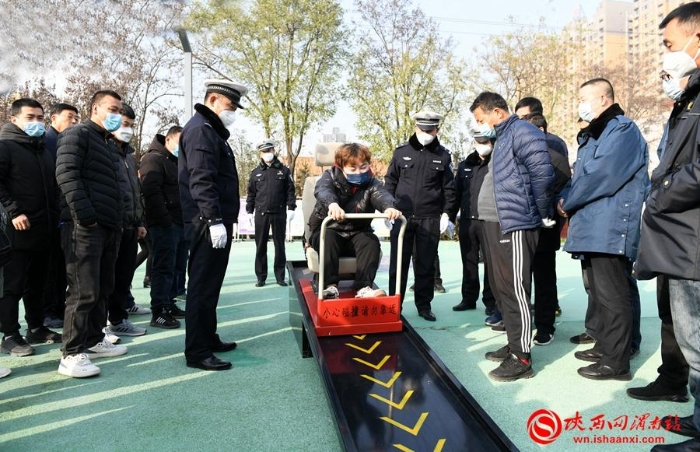 民警引导群众体验安全带的保护作用。记者 许艾学 摄