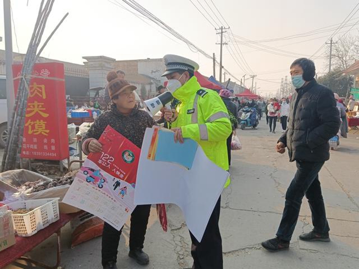 1月3日，大荔交警向采购年货的群众发放交通安全宣传年画进行宣传。
