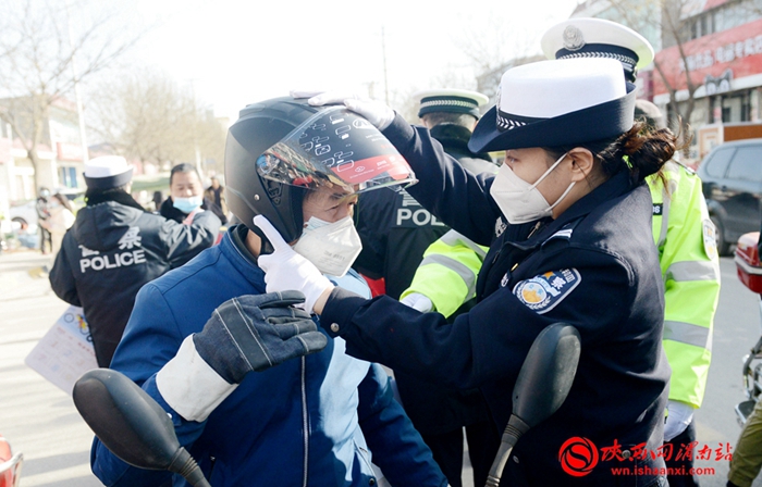 1月6日，“平安春运 交警同行暨美丽乡村行交通安全巡回宣传渭南富平站”活动中，交警向赶集群众赠送头盔。记者 杨大君 摄