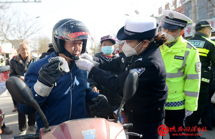 宣传人员向农民朋友进行交通安全针对性宣传教并赠送头盔。记者 杨大君 摄