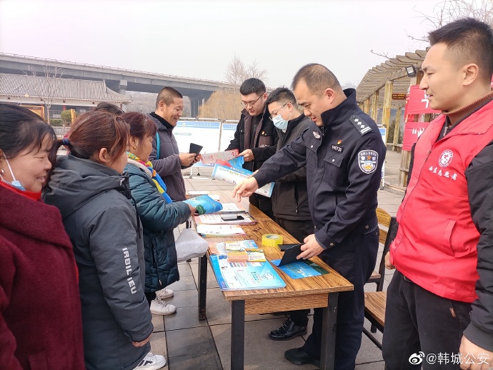 韩城公安西庄所民辅警在辖区广场，拉横幅、讲展板，向辖区群众宣传讲解防电信诈骗和禁毒典型案例。