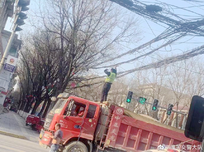 电缆掉落致交通受阻，潼关交警秒变“托举哥”保畅通。