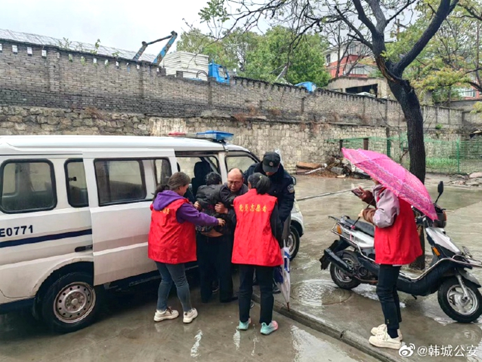 大雨磅礴，民警护送老人回家。