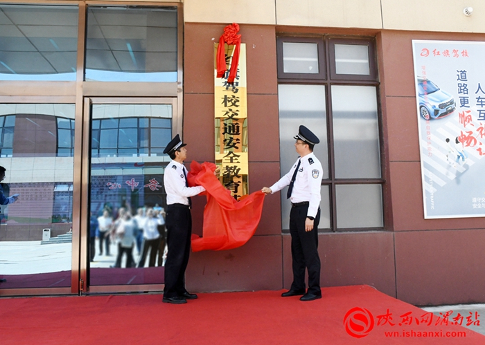 陕西省公安厅交警总队政委郝新岐，渭南市公安局党委委员、交警支队支队长闫丰胜为红旗驾校交通安全宣传教育基地揭牌。记者 王清 摄