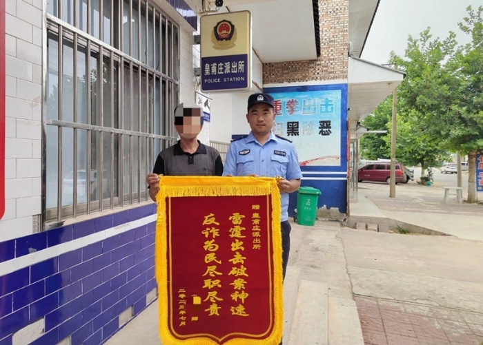 王某将一副印有“雷霆出击破案神速、反诈为民尽职尽责”的锦旗递到民警手中。