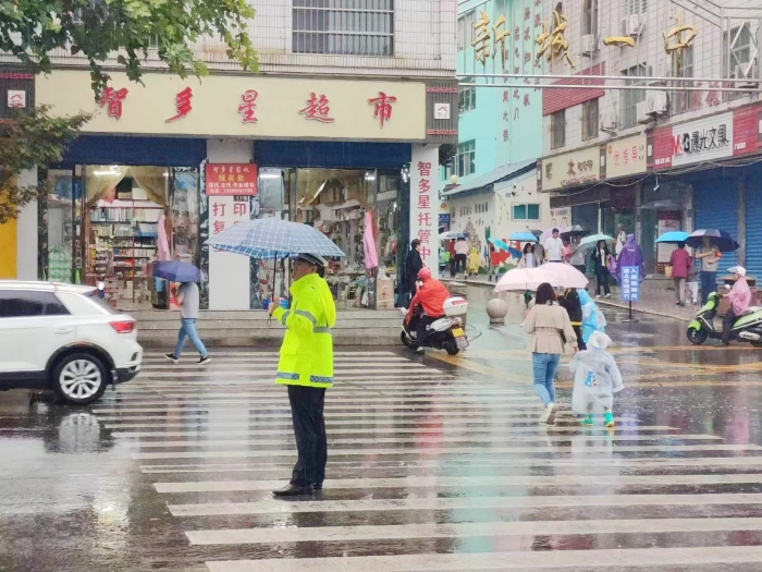 韓城交警雨中執勤確保學校門前及周邊道路交通安全暢通。