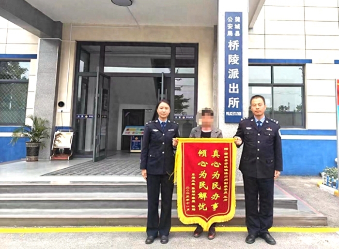 程女士将一面印有“真心为民办事 倾心为民解忧”字样的感谢的锦旗送到蒲城县公安局桥陵派出所民警手中。
