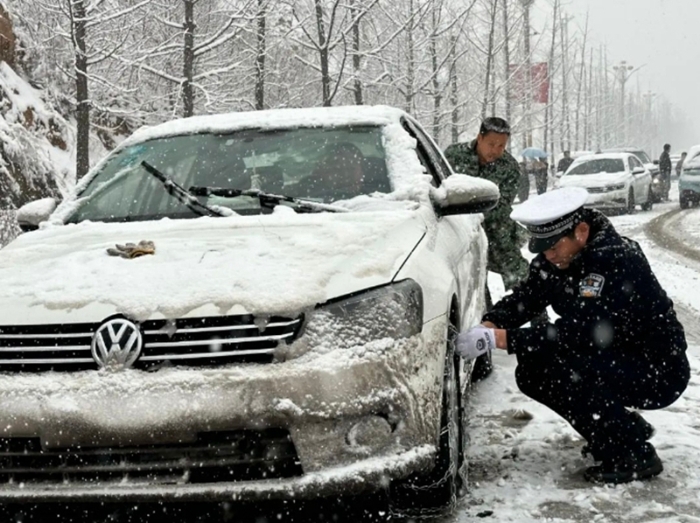 民警们积极帮助车主推车并安装防滑链。