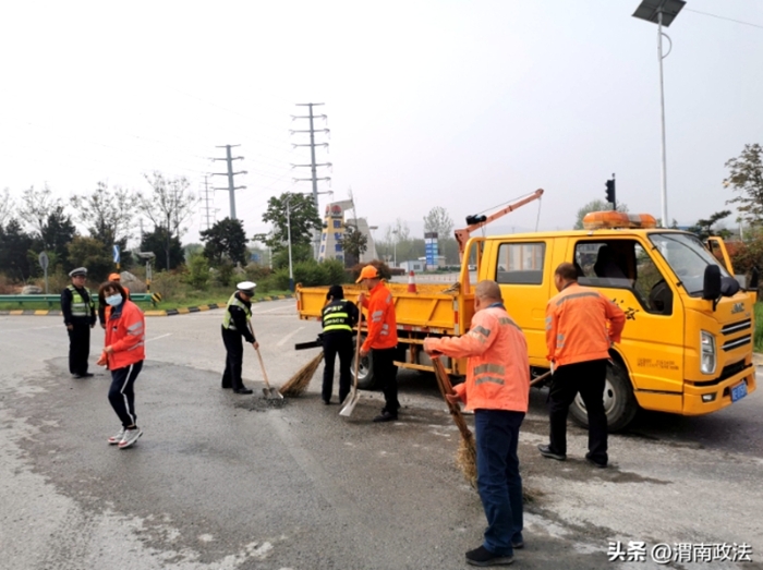 华州公安交警联合公路养护部门清理路面积沙。