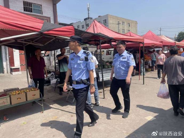 韩城公安龙门派出所民警在集市的广场进行巡逻和宣传工作。