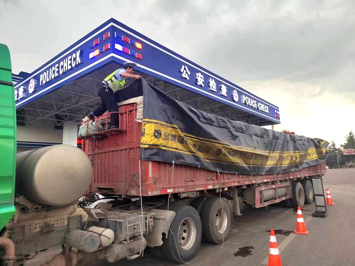 雷阵雨前，白水交警帮助驾驶人遮盖篷布。