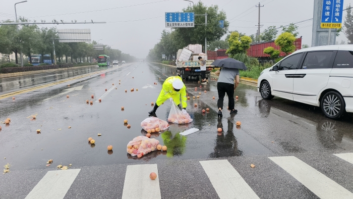 雨天车辆打滑货物散落路面，大荔交警冒雨暖心相助。