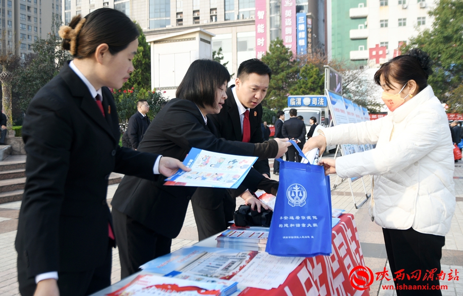 工作人员向过往群众发放平安临渭建设宣传资料、宣传小礼品。记者 陈冰娟 摄