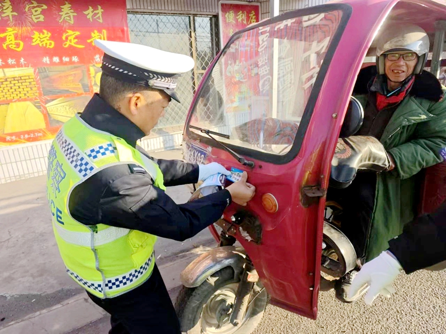 合阳交警为来往二、三轮电动车粘贴反光贴。