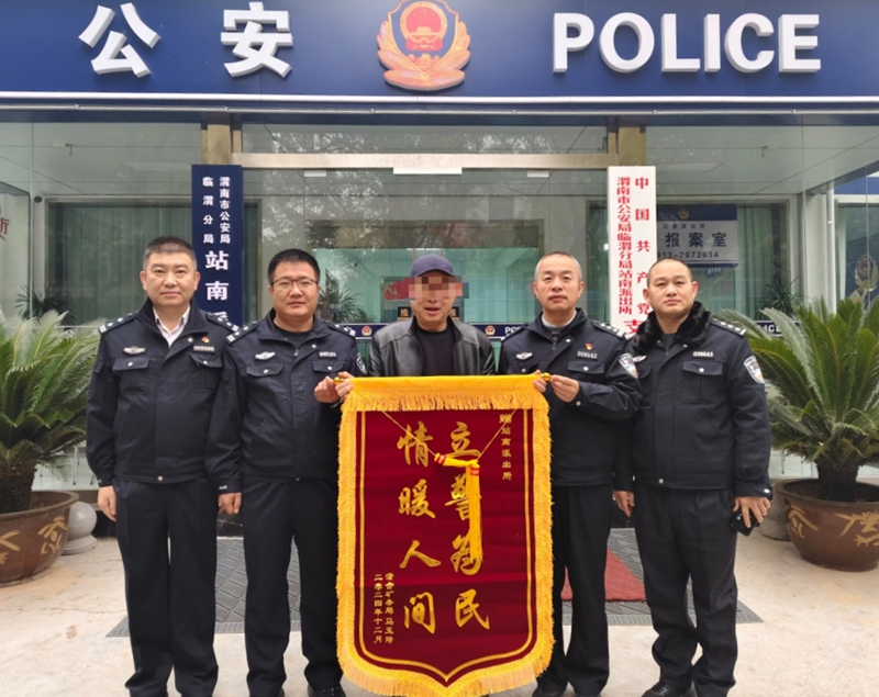 马先生将一面锦旗送到临渭公安分局站南派出所民警手中，为民警暖心帮助其找回“丢失”车辆点赞。