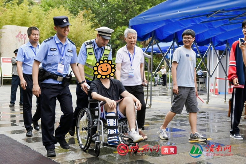 民警帮助受伤考生进入考场。记者 许艾学 摄