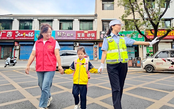 9月2日，合阳交警和家长志愿者护航学生安全过马路。