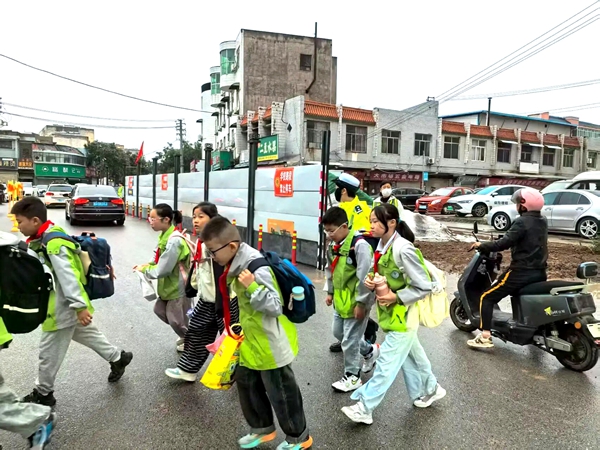 白水公安交警雨中坚守护学岗，为师生撑起“平安伞”。