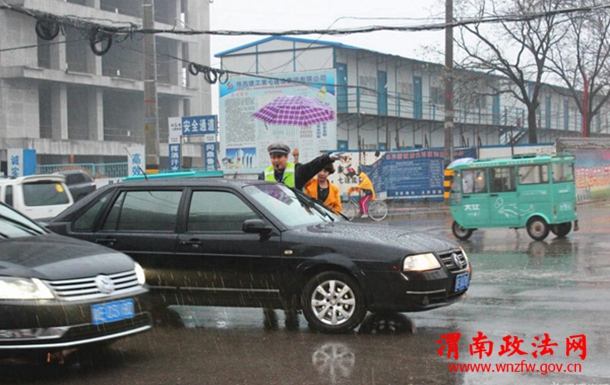 清明节期间，渭南市区东风大街与民生路十字口，瓢泼大雨中执勤疏导的交警，感动了途经此处的市民，一位女士发自内心的为民警撑起爱心伞。