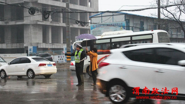 清明节期间，渭南市区东风大街与民生路十字口，瓢泼大雨中执勤疏导的交警，感动了途经此处的市民，一位女士发自内心的为民警撑起爱心伞。